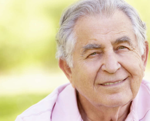 doso sorrindo em ambiente natural, simbolizando o envelhecimento saudável e a diferença entre senescência e senilidade.