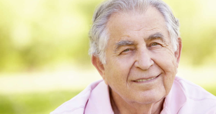 doso sorrindo em ambiente natural, simbolizando o envelhecimento saudável e a diferença entre senescência e senilidade.