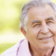 doso sorrindo em ambiente natural, simbolizando o envelhecimento saudável e a diferença entre senescência e senilidade.